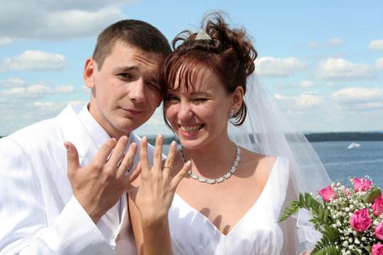 the bride and groom show off wedding rings