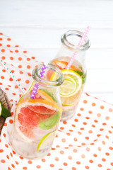 Infused flavored water with fresh fruits on white wooden background.Refreshing summer homemade  detox water