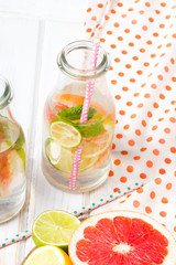 Infused flavored water with fresh fruits on white wooden background.Refreshing summer homemade  detox water