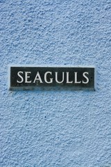 Seagulls plaque on a blue stone wall