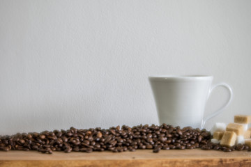 white coffee mug and coffee beans with sugar cubes