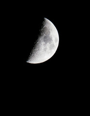 vertical view of first quarter moon in the night sky