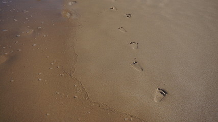 Fototapeta na wymiar child foot print on wet sand