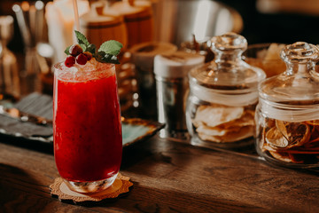red cocktail with mint on bar table