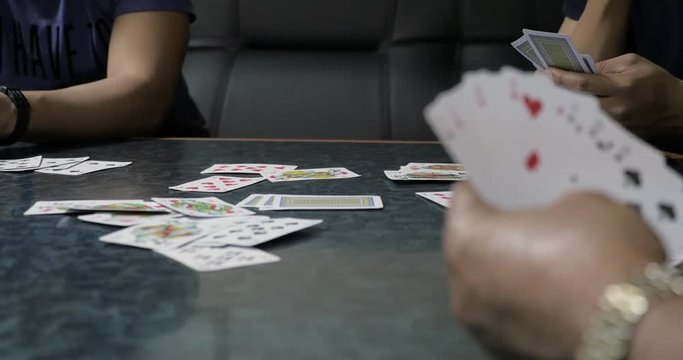 Playing cards in man's hand on table