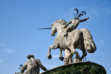 Statue of Neptune with a raised hand holding a trident, in the gardens of Isola Bella in Lago Maggiore, Italy