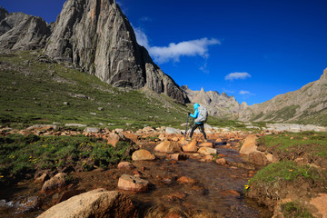 Obraz premium Young woman with backpack walking on mountain