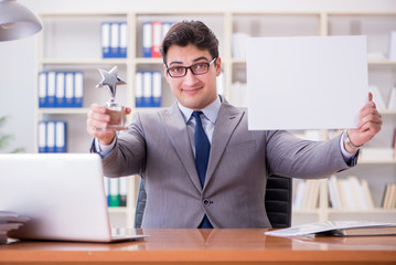Naklejka premium Businessman in office holding a blank message board