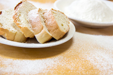 Slices of bread and wheat flour in a white plate on the table