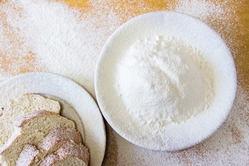 Slices of bread and wheat flour in a white plate on the table
