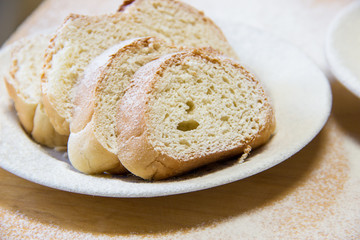 Poudered slices of bread in a white plate on the table
