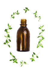 Bottle of essential oil with herbs thyme isolated on white background