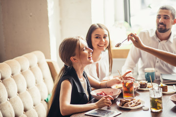 glamourous young woman laughing, feeding ice-cream to her friend