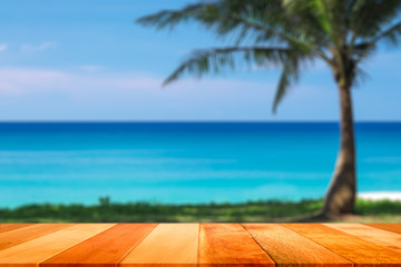 Fototapeta premium Wood plank with blurred sea and coconut tree background. Concept of beach in summer.