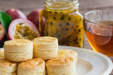 Homemade plain scones serve with homemade passion fruit jam and tea. Scones is English pastry for afternoon tea,cream tea. Delicious plain scones in Devon shire or Cornish cream style for tea time.