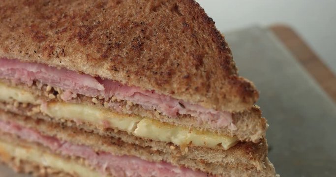 Cooking a rustic brie and ham sandwich with mustard sauce in an industrial style kitchen