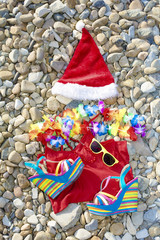 Beach holiday Santa Claus items lying on the stony coast