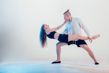 modern style beautiful dancers working out. Young man holding his girl partner