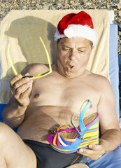 Obraz premium Santa Claus is resting on the Sunset on the beach