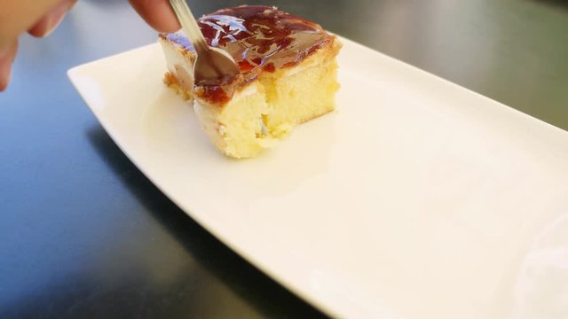 Footage of a person at a caffee eating a delicious cake, tres leches...