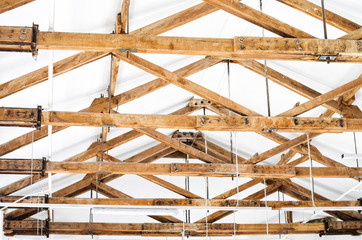 Wooden Roof Structure in White Bright Interior. Old Rafters in the Loft Interior