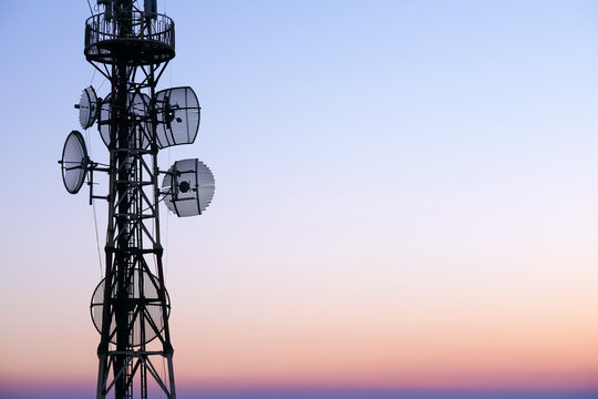 Telecommunication tower Antenna at sunset sky.