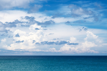 Fototapeta na wymiar Blue sea with big white clouds and sky.