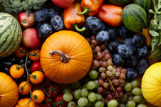Fototapeta Autumn harvest concept. Seasonal fruits and vegetables on a wooden table, top view