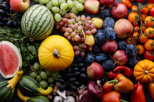 Fototapeta Autumn harvest concept. Seasonal fruits and vegetables on a stone tabletop, top view