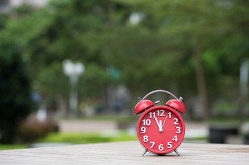 Retro alarm clock with five minutes to twelve o'clock.