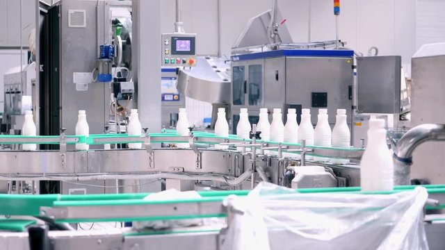 Footage of milk bottles at the production line in a milk company