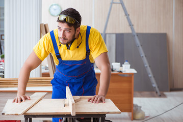 Young repairman carpenter working with a circular saw
