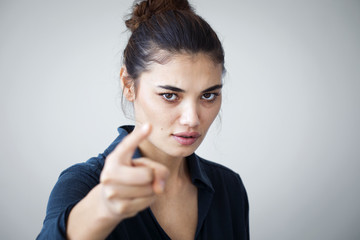 Angry woman pointing isolated on gray background