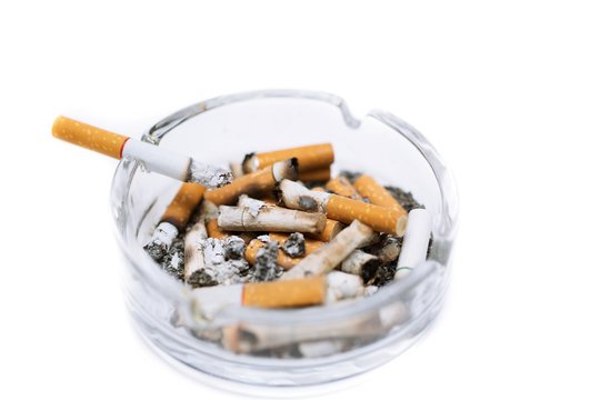 smoking a cigarette on ashtray in white background.