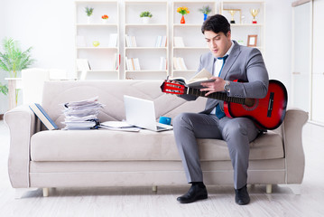 Businessman playing guitar at home