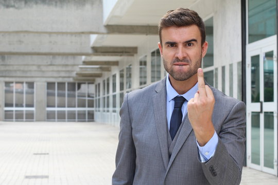 Mad businessman showing rage with middle finger