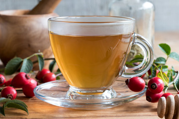 A cup of freshly prepared rosehip tea on a wooden table