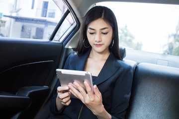 Woman using Smartphone for working in car, Woman working concept.