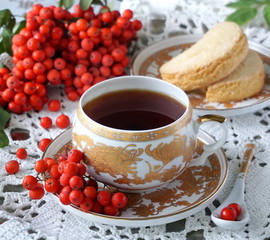 A cup of black tea, biscuits and rowan