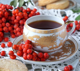 A cup of black tea, biscuits and rowan