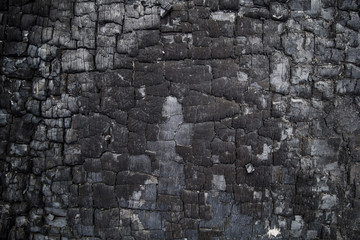 close up texture of burned wooden wall, charred black background