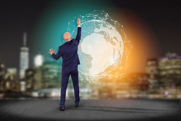Businessman in front of a wall with International network displayed on a futuristic interface with...