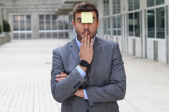 Surprised businessman with a note on his forehead 