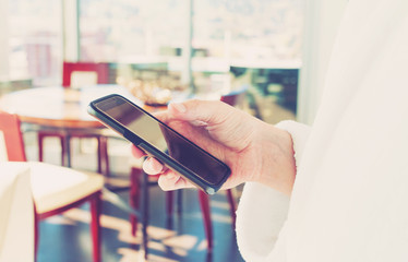 Man in a bathrobe using his smartphone indoors