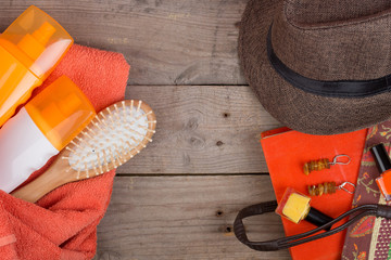 Beach accessories - hairbrush, orange towel, hat, sun cream, lotion, beach bag, nail polish, a book...