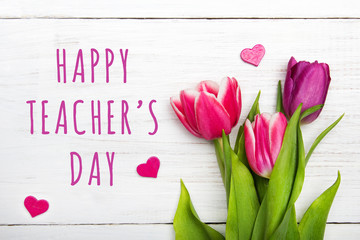 Happy Teacher's day card. Tulip on white wooden background