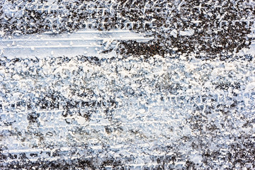 Obraz premium Texture of road in winter, asphalt covered snow and tire tracks
