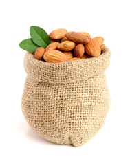 Almonds with leaf in bag from sacking isolated on white background