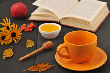 Autumn still life cup of tea, honey and book on the table