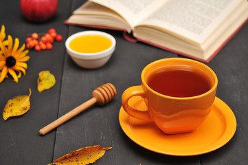 Autumn still life cup of tea, honey and book on the table